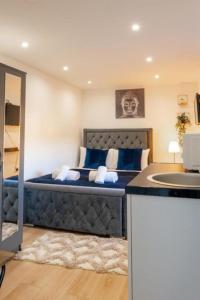 a bedroom with a blue bed with a sink at UB2 Suites - Heathrow London in Southall