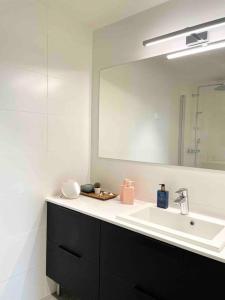 ein Bad mit einem Waschbecken und einem Spiegel in der Unterkunft Stunning 90 square meter apart with 3br + rooftop in Tampere