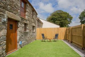 a backyard with two chairs and a fence at Piglets. Spacious, Modern, Peaceful, nr Port Isaac in Camelford