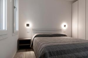 a white bedroom with a bed and a window at Residence Cavalli in Mestre