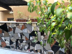 een mozaïektegels muur met een plant op een richel bij Hanna's Place - Great Location in Eilat