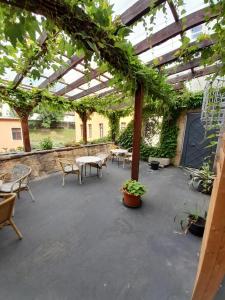 un patio con mesas, sillas y plantas en Schloss Schänke Hotel garni und Weinverkauf, en Bautzen