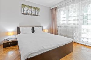 ein Schlafzimmer mit einem großen Bett und einem großen Fenster in der Unterkunft Apartament Helena in Oradea