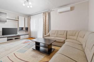 ein Wohnzimmer mit einem Sofa und einem Tisch in der Unterkunft Apartament Helena in Oradea