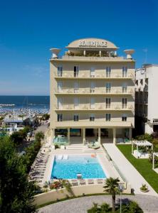 a hotel with a swimming pool in front of a building at Hotel Beaurivage in Cattolica