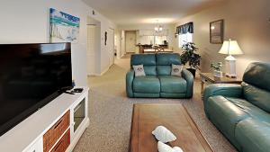 uma sala de estar com um sofá e uma televisão em Experience Tranquility at Summertree Village Condo em Myrtle Beach