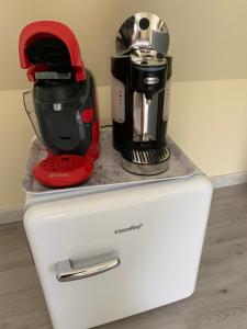 a red and black coffee maker on top of a refrigerator at Chambre à la campagne in Hauville