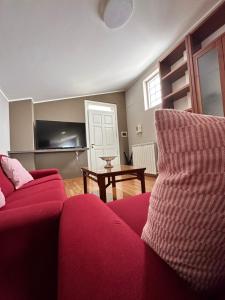 een woonkamer met een rode bank en een tafel bij Casa Olivastri in Treglio