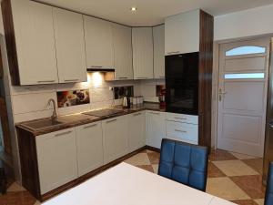 a kitchen with white cabinets and a black appliances at Pokoj agroturystyczny in Mieroszyno
