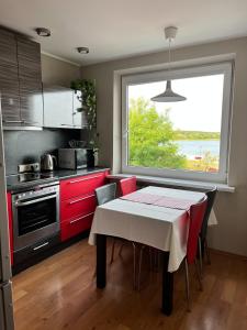 a kitchen with a table with red cabinets and a window at Lakeview Retreat in Vievis in Vievis