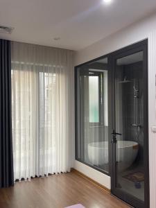 ein Badezimmer mit einer großen Glastür und einer Badewanne in der Unterkunft Alala Homestay- Trung tâm thành phố Tuyên Quang- Tuyên Quang City Center in Tuyên Quang