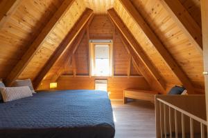 a bedroom in a log cabin with a bed at HA 9 - Strandvogt 3 Komfort in Schottwarden