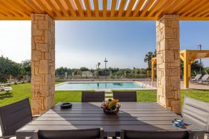 a patio with a table and chairs and a pool at Villa Sandi with Private Pool in Hersonissos