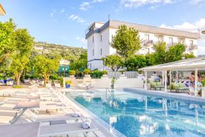 uma piscina do hotel com espreguiçadeiras e um edifício em Hotel Florida em Sorrento