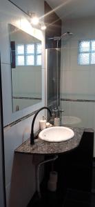 un baño con lavabo y espejo en Casa Ton Trevelin, en Trevelín