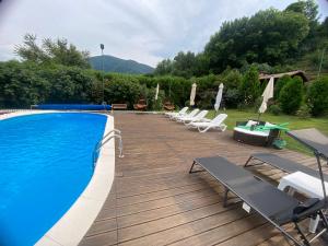 a swimming pool with lounge chairs and a deck at CASA DRENCOVA SRL in Berzasca