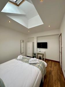 sypialnia z dużym białym łóżkiem i świetlikiem w obiekcie 2 Sheraton Apartments w mieście Fort William