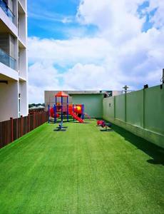 a playground on the roof of a building with green grass at KSL City Mall D'esplanade Muji Style Studio in Johor Bahru