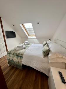 a bedroom with a large white bed with a window at 2 Sheraton Apartments in Fort William