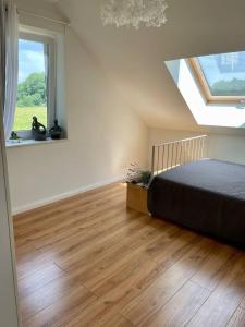 um quarto com uma cama e uma grande janela em Familienfreundlichen Apartment mit traumhaft grüner Aussicht em Hamburgo