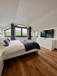 a bedroom with a large bed and a flat screen tv at 2 Sheraton Apartments in Fort William