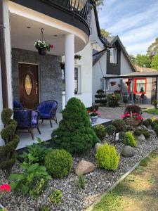 a front yard with a patio with chairs and plants at Dom Gościnny Paweł&Kasia Kaczor in Pobierowo