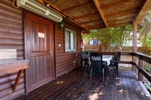 a porch of a cabin with a table and chairs at Belfer's Dead Sea Cabins in Neʼot HaKikar