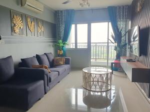Apartment Servis UITM Puncak Alam في Bandar Puncak Alam: غرفة معيشة مع أريكة وطاولة