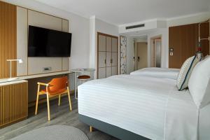 a hotel room with a large bed and a flat screen tv at Malta Marriott Resort & Spa in St. Julianʼs
