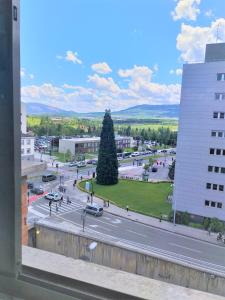 a view from a window of a street with a tree at Pensión Pamplonabeds in Pamplona