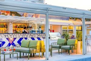 een restaurant met een bar met groene stoelen en een zwembad bij Hotel Florida in Sorrento