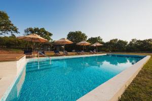 a large swimming pool with umbrellas and chairs at KOKO VILLAGE in Podgorica