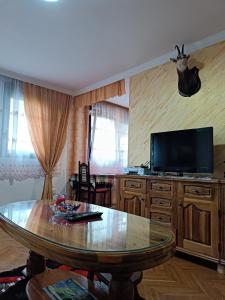 a living room with a table and a flat screen tv at Divine Apartment in Pluzine