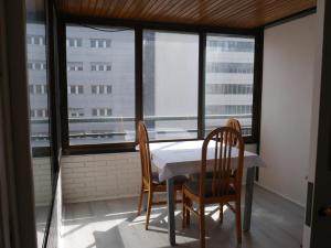 uma mesa e duas cadeiras num quarto com uma janela em Pensión Pamplonabeds em Pamplona