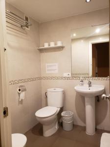a bathroom with a toilet and a sink at Pensión Pamplonabeds in Pamplona