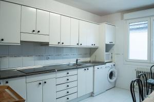 a white kitchen with a sink and a dishwasher at Coqueto apartamento 2 dormitorios in Pamplona
