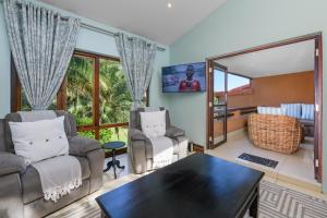 een woonkamer met 2 stoelen en een tafel bij San Lameer Villa 2806 - 3 Bedroom Classic - 6 pax - San Lameer Rental Agency in Southbroom