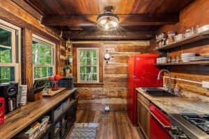 a kitchen with a red refrigerator and wooden walls at Boozy Bear Bungalow romantic cabin 5 mins 2 downtown with hot tub and fire pit in Gatlinburg