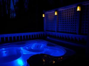 a blue bath tub in a dark room with lights at Boozy Bear Bungalow romantic cabin 5 mins 2 downtown with hot tub and fire pit in Gatlinburg