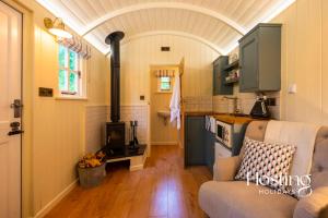 a kitchen with a couch and a stove in a room at Red Kite Retreat - Pansy - Shepherds Hut 3 in Henley on Thames