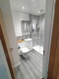 a white bathroom with a toilet and a shower at A view to Caol, Fort William in Fort William