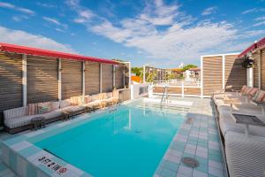 a large swimming pool with chairs at Esme Miami Beach in Miami Beach