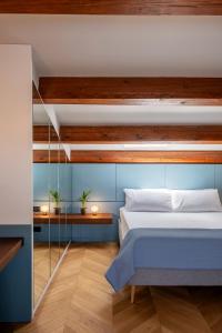 a bedroom with a bed with blue walls and wooden ceilings at Dimora Condivi in Ripatransone +24 photos