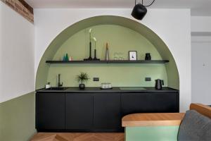 a kitchen with a black counter and an archway at Dimora Condivi in Ripatransone