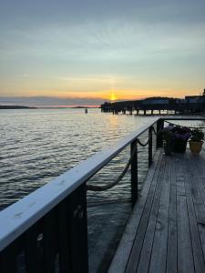 a pier with flowers and a sunset on the water at Alert Bay Sweet Home in Alert Bay