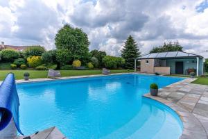 a large blue swimming pool in a yard at Casa des Augas in Ousse