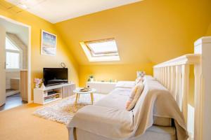 a childs bedroom with a white bed and yellow walls at Casa des Augas in Ousse