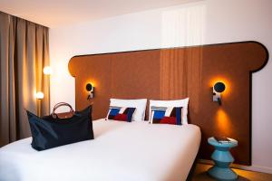 een hotelkamer met een groot bed met kussens bij Mercure Dunkerque Centre Gare in Duinkerke