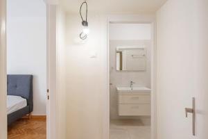 Baño blanco con lavabo y espejo en Spacious 3 bedroom apt in Eksarchia en Atenas