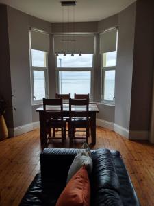 ein Wohnzimmer mit einem Sofa und einem Esstisch in der Unterkunft Snooze Apartments in Newcastle